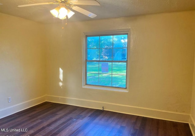 unfurnished room featuring a ceiling fan, baseboards, and dark wood-type flooring