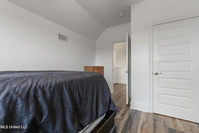 unfurnished bedroom featuring dark hardwood / wood-style flooring and lofted ceiling