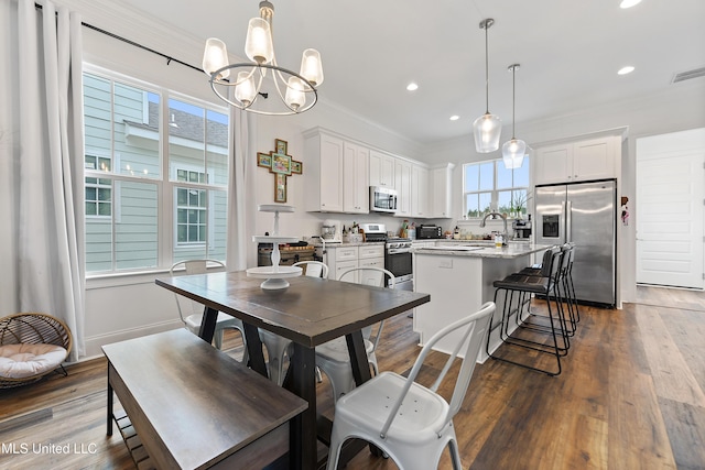 dining room with ornamental molding, plenty of natural light, and dark wood-type flooring