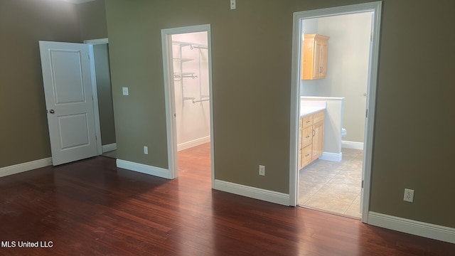 4509 Hickory St, Pascagoula, MS 39567 - unfurnished bedroom featuring wood finished floors, a walk in closet, connected bathroom, and a closet