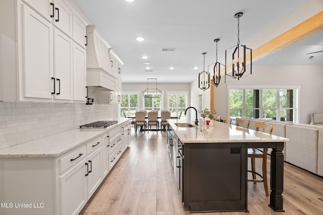4270 Sunset Rd, Nesbit, MS 38651 - kitchen featuring white cabinetry, visible vents, a breakfast bar, open floor plan, and stainless steel gas cooktop