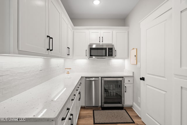4270 Sunset Rd, Nesbit, MS 38651 - kitchen with beverage cooler, light stone counters, decorative backsplash, stainless steel microwave, and white cabinetry