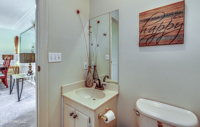 bathroom with vanity, crown molding, and toilet