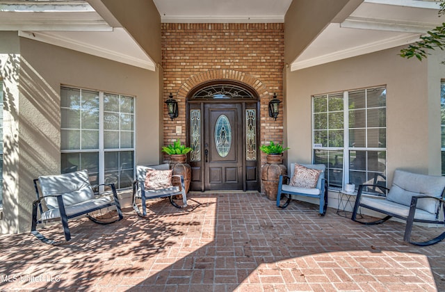 property entrance with brick siding and stucco siding