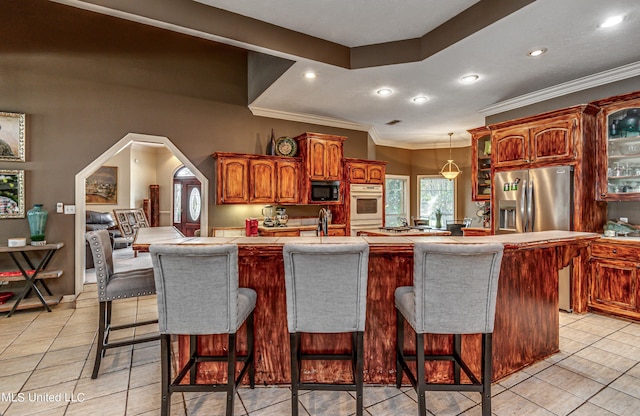 kitchen with light tile patterned floors, black microwave, a kitchen bar, and glass insert cabinets