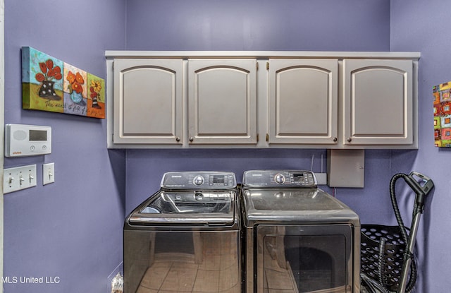 clothes washing area featuring cabinet space and washing machine and dryer