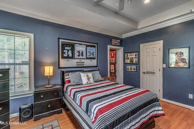 bedroom with baseboards, ornamental molding, and wood finished floors