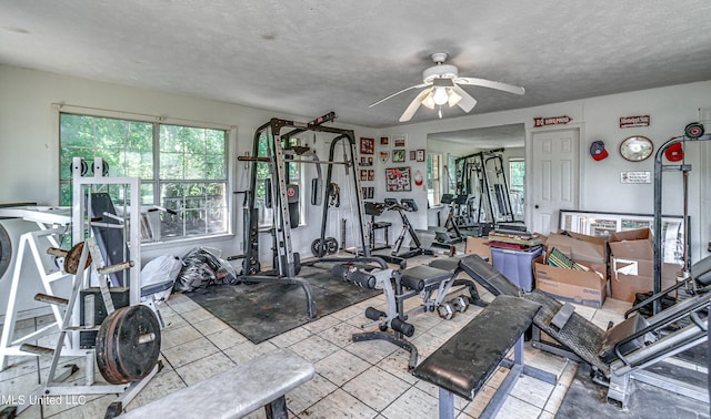 workout area with a ceiling fan and a textured ceiling