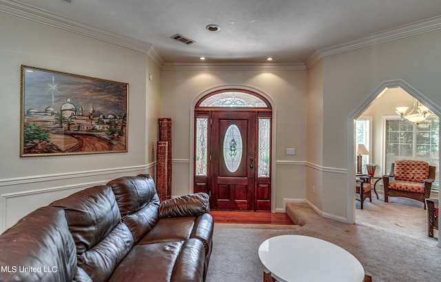 foyer entrance with crown molding and light colored carpet