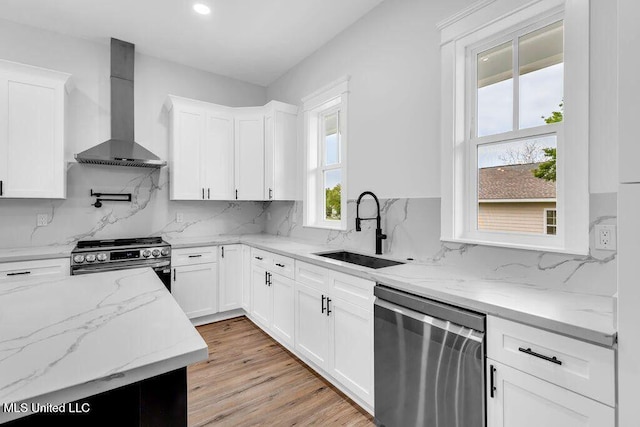 414 Shell St, Biloxi, MS 39530 - kitchen with stainless steel appliances, wall chimney range hood, a sink, white cabinets, and tasteful backsplash