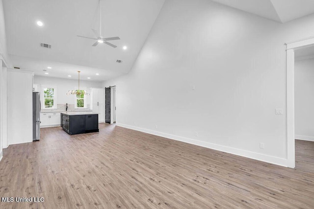 414 Shell St, Biloxi, MS 39530 - unfurnished living room featuring ceiling fan, recessed lighting, light wood-style flooring, high vaulted ceiling, and baseboards