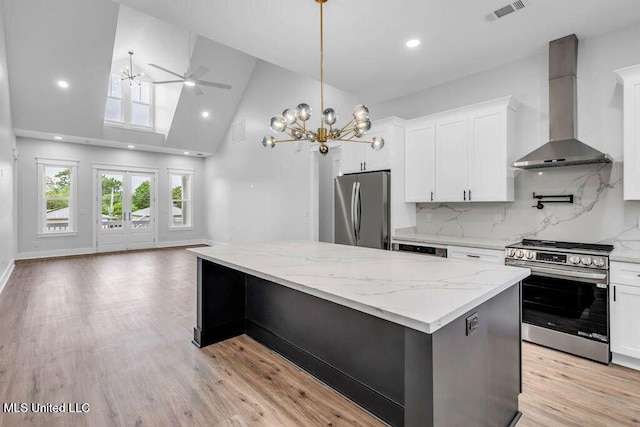 414 Shell St, Biloxi, MS 39530 - kitchen featuring stainless steel appliances, wall chimney exhaust hood, a ceiling fan, open floor plan, and a kitchen island