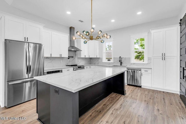414 Shell St, Biloxi, MS 39530 - kitchen with appliances with stainless steel finishes, wall chimney exhaust hood, a sink, white cabinetry, and recessed lighting