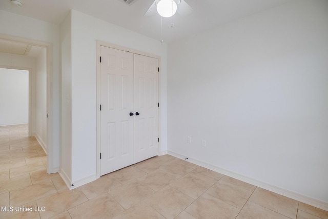 unfurnished bedroom with light tile patterned floors, a closet, and ceiling fan