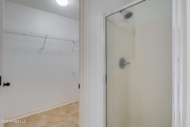 bathroom with tile patterned flooring and a shower with shower door