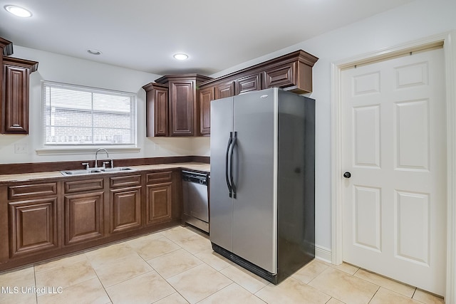 kitchen featuring dark brown cabinets, light tile patterned flooring, sink, and stainless steel appliances