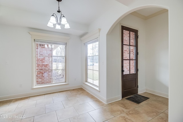 tiled entrance foyer featuring an inviting chandelier