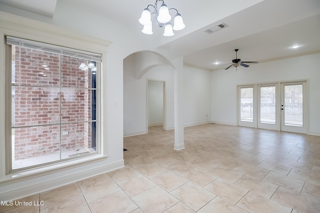 tiled spare room featuring ceiling fan with notable chandelier and a healthy amount of sunlight