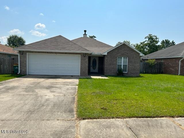 single story home with a garage and a front lawn