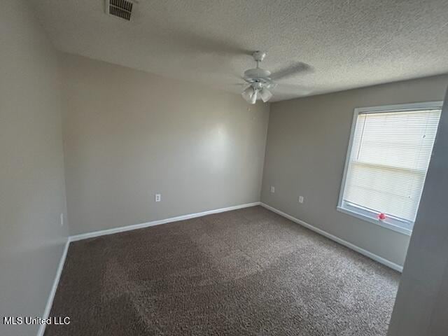 carpeted spare room with a textured ceiling and ceiling fan