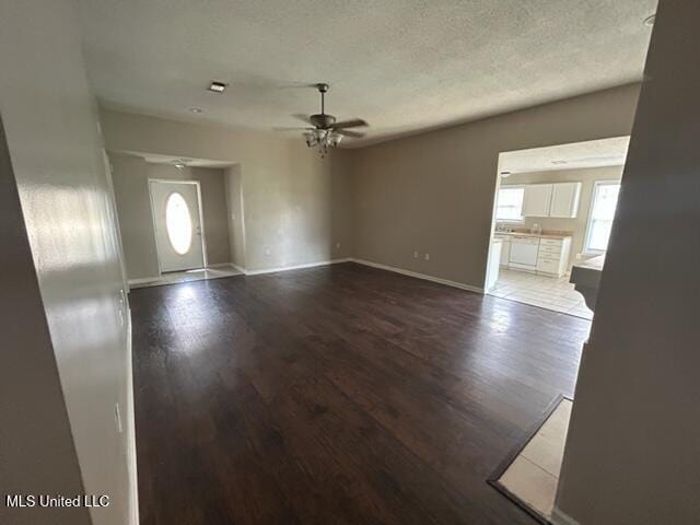 interior space featuring ceiling fan, wood-type flooring, and a textured ceiling