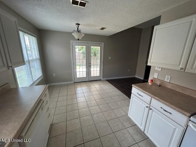 kitchen featuring french doors, white cabinets, pendant lighting, and white dishwasher