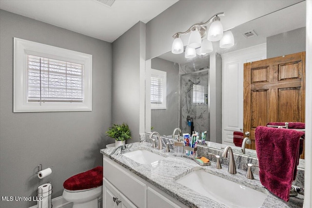 bathroom with toilet, vanity, and a shower with shower door