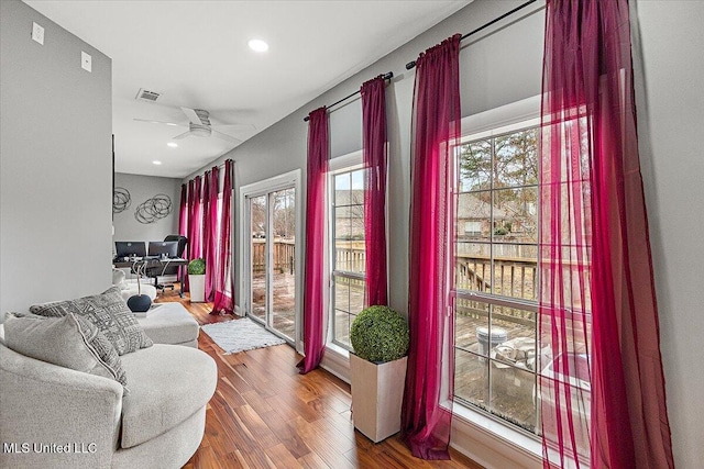 living area with hardwood / wood-style flooring and ceiling fan