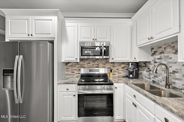 kitchen featuring tasteful backsplash, sink, white cabinets, and appliances with stainless steel finishes