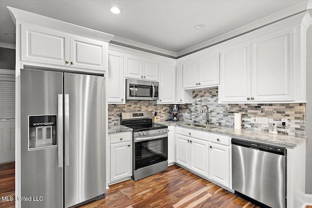 kitchen with white cabinetry, appliances with stainless steel finishes, sink, and light stone counters