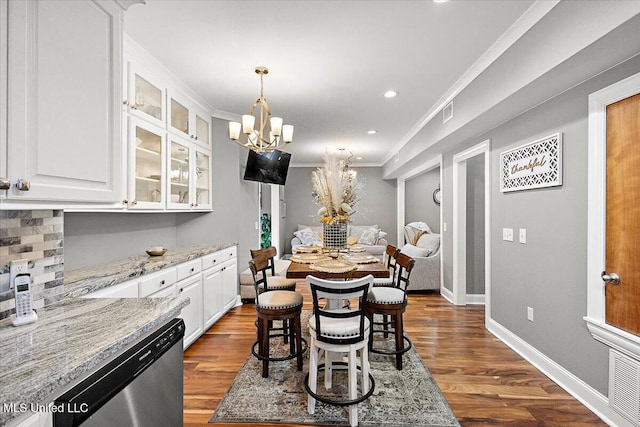 dining room featuring ornamental molding, dark hardwood / wood-style floors, and an inviting chandelier