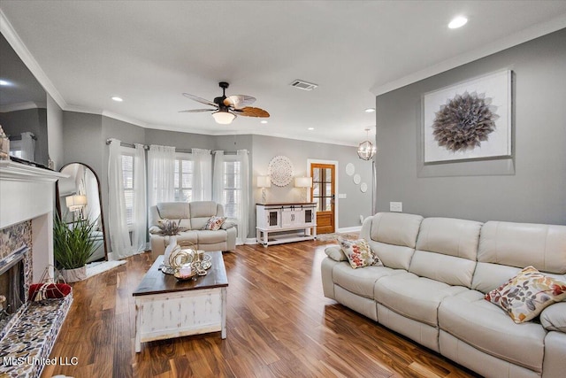 living room featuring crown molding, wood-type flooring, and ceiling fan