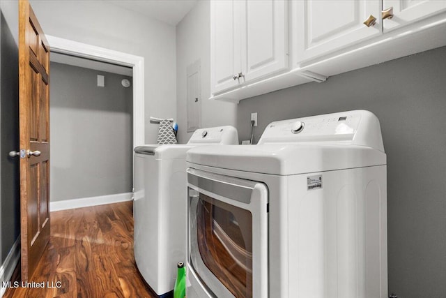 clothes washing area featuring cabinets, dark hardwood / wood-style floors, and washing machine and dryer