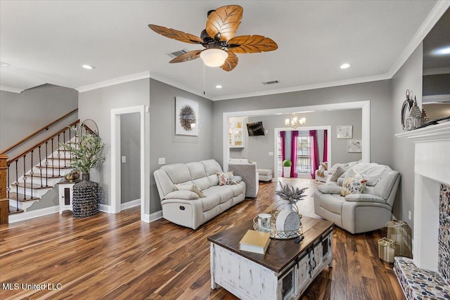 living room with ceiling fan with notable chandelier, ornamental molding, and dark hardwood / wood-style floors