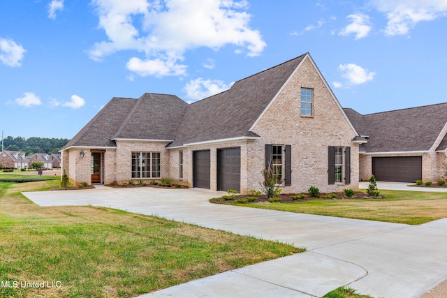view of front of property featuring an attached garage, driveway, a front lawn, and brick siding