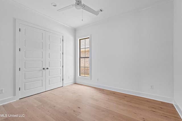 unfurnished bedroom with baseboards, crown molding, light wood-style floors, and visible vents