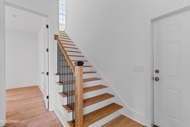 stairs with baseboards and wood finished floors