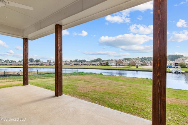 view of patio featuring a residential view, a water view, and fence