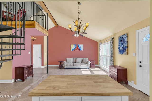 entryway with light tile patterned floors, high vaulted ceiling, and a chandelier