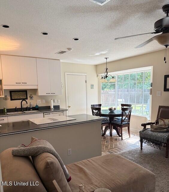 2246 Baywood Dr, Biloxi, MS 39532 - kitchen with a sink, dark countertops, white cabinetry, ceiling fan, and decorative light fixtures