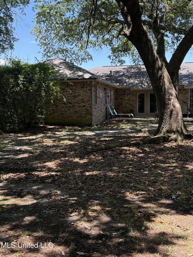2246 Baywood Dr, Biloxi, MS 39532 - view of side of home with brick siding, roof with shingles, and french doors