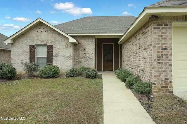 view of exterior entry with a lawn