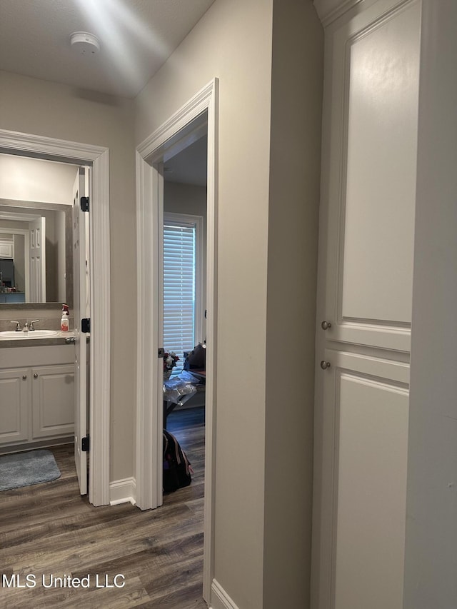 109 Brunswick Cv, Canton, MS 39046 - hallway with a sink, dark wood-style floors, and baseboards