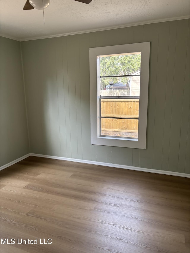 spare room featuring crown molding and light wood-type flooring