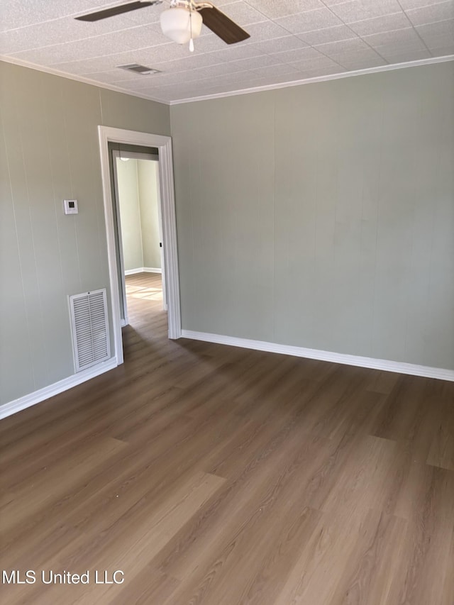 unfurnished room with ornamental molding, hardwood / wood-style floors, and ceiling fan