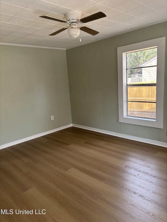 spare room featuring ceiling fan, ornamental molding, and dark hardwood / wood-style flooring