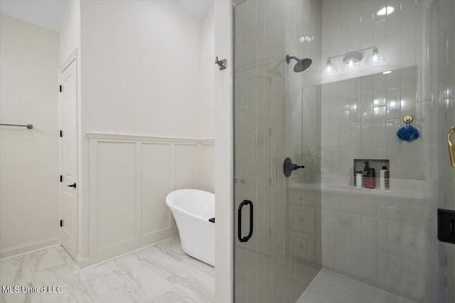 6603 Wirtz Rd, Flowood, MS 39232 - full bath featuring a shower stall, marble look tiles, a soaking tub, a decorative wall, and a wainscoted wall