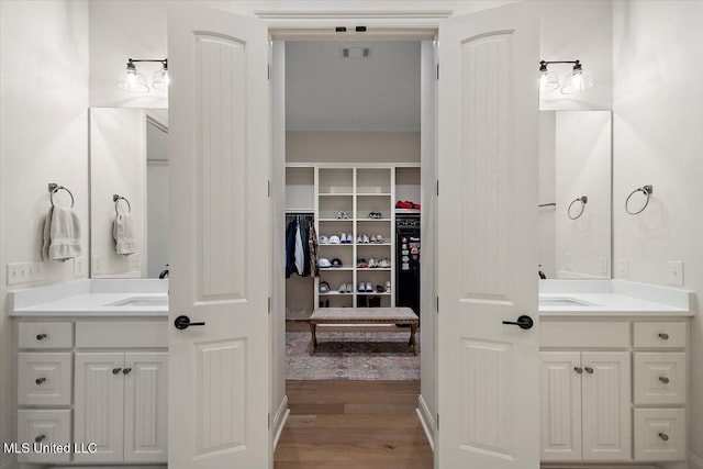 6603 Wirtz Rd, Flowood, MS 39232 - full bath featuring two vanities, wood finished floors, and a walk in closet