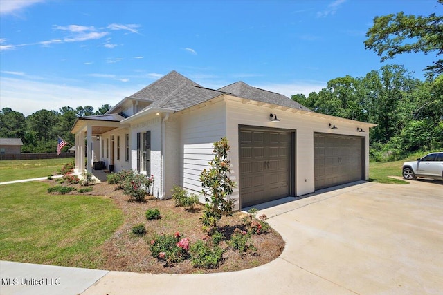 6603 Wirtz Rd, Flowood, MS 39232 - view of side of property featuring an attached garage, a lawn, concrete driveway, and a shingled roof