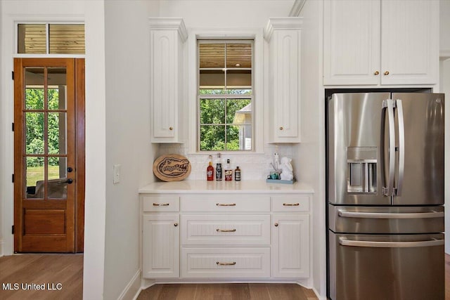 6603 Wirtz Rd, Flowood, MS 39232 - kitchen with stainless steel fridge, white cabinetry, decorative backsplash, and wood finished floors